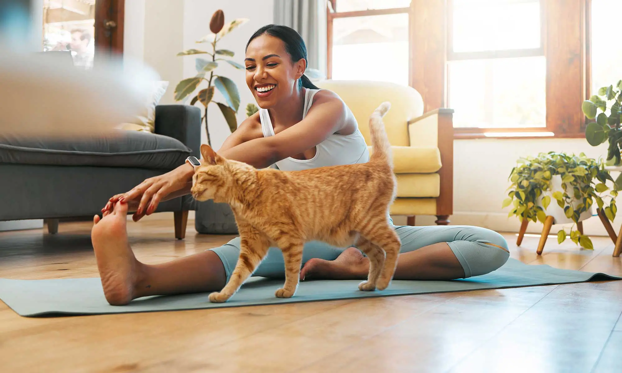 A woman stretching with her cat